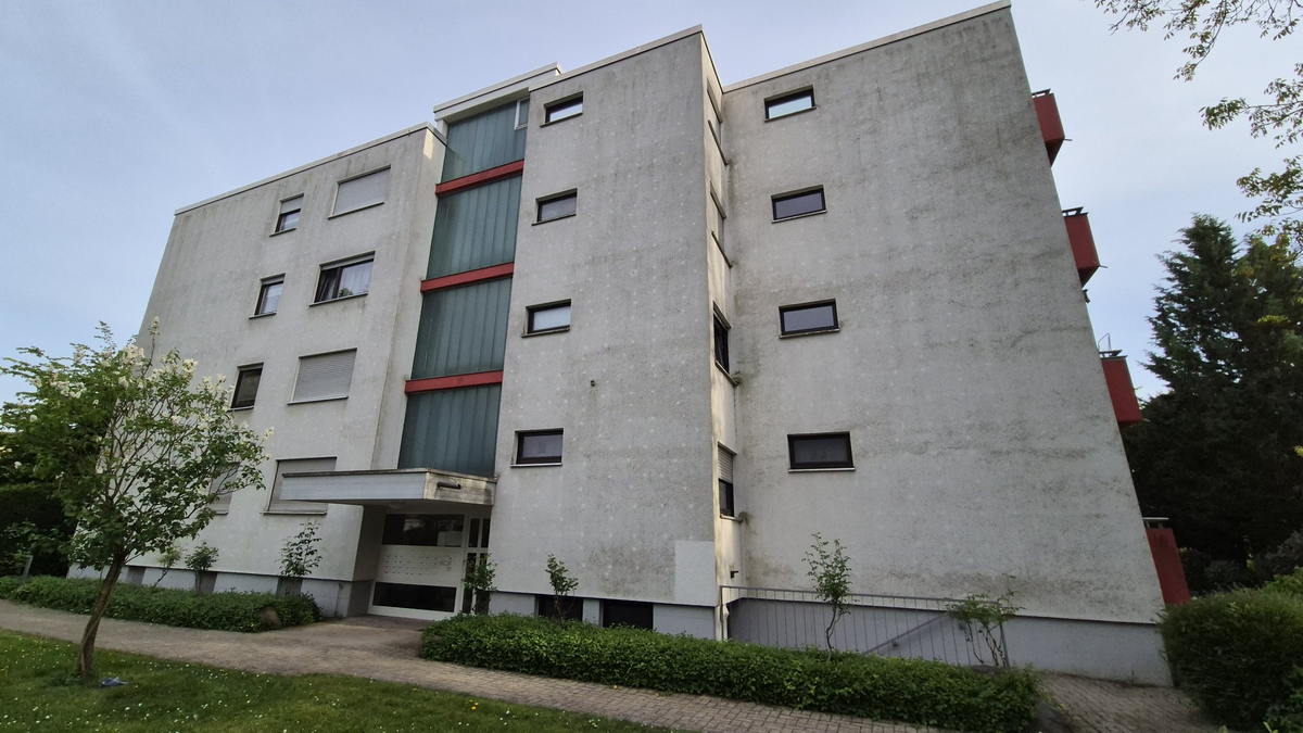 Vierstöckige Wohnanlage mit grau verschmutzter Fassade vor der Reinigung