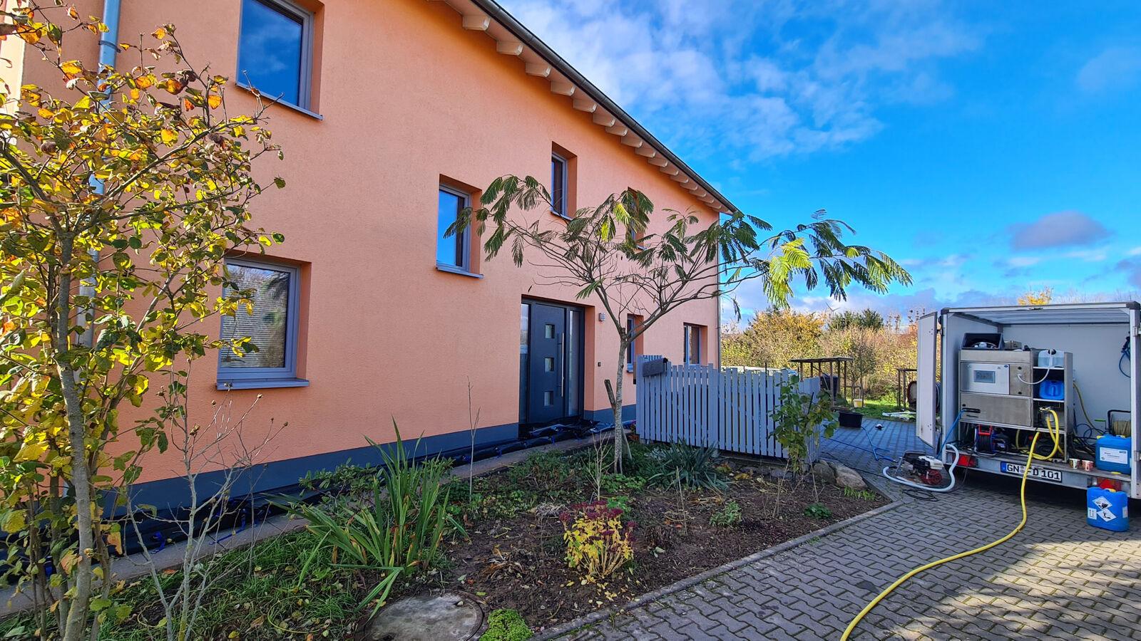 Fahrzeug der Fassaden-Dusche vor einem frisch gereinigten Wohnhaus